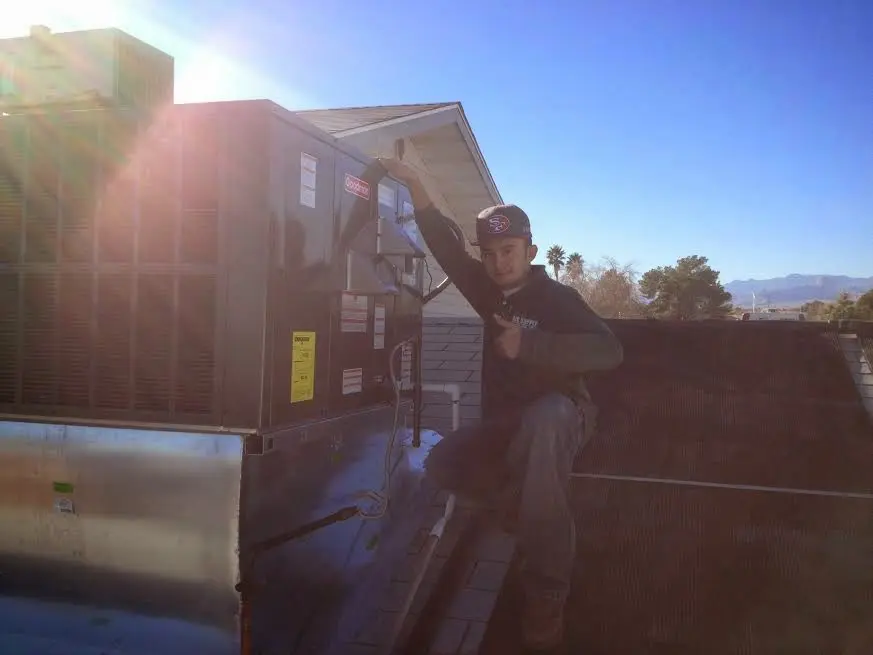 HVAC technician performing Boiler Repair on a rooftop unit in Madison